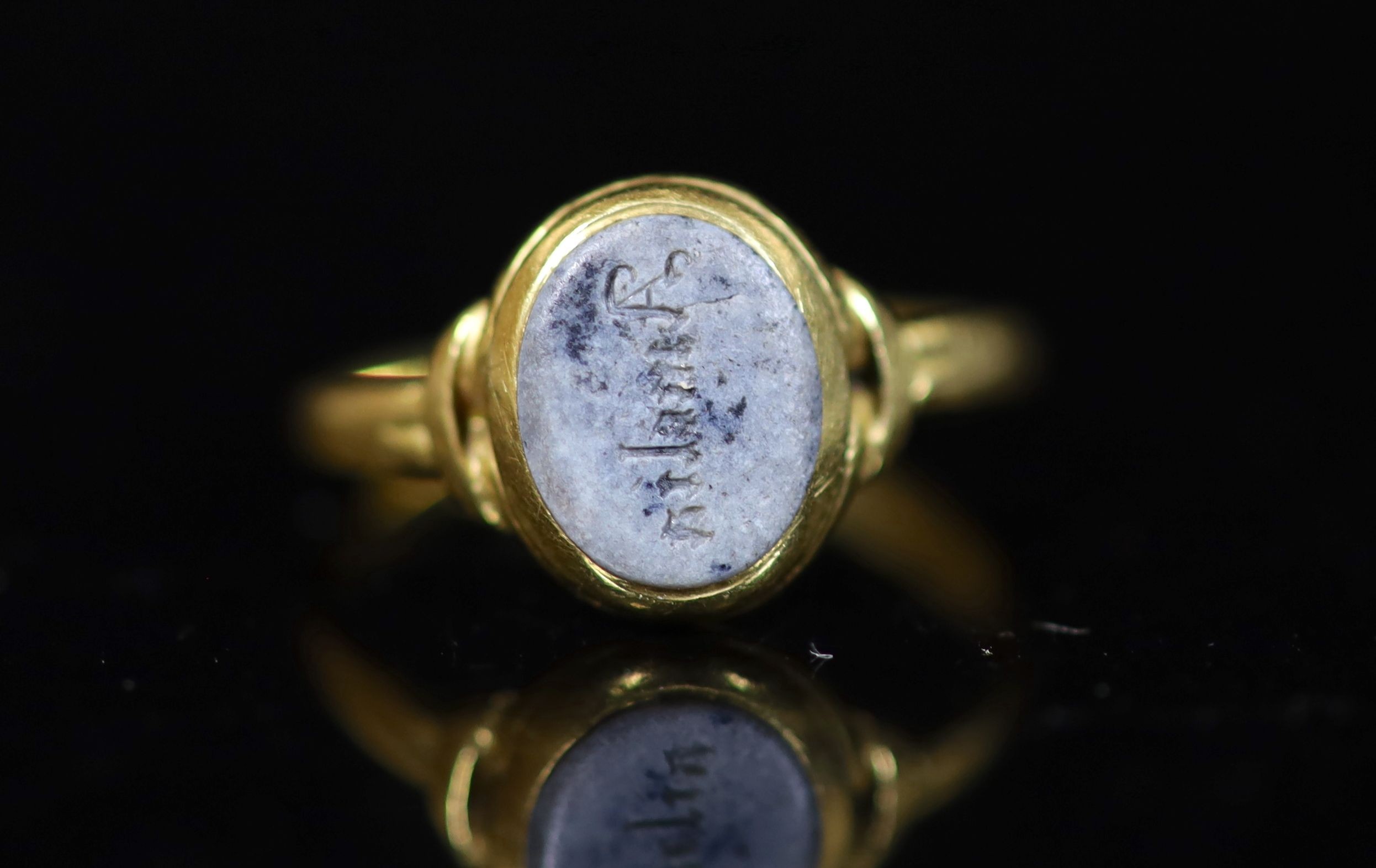 An antique gold and oval chalcedony set ring, carved with the name 'Amelia'